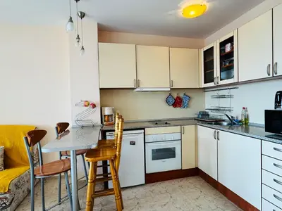 a kitchen with white cabinets and a table and chairs at LAZUR 1 Apartment 7- 5 Sveti Vlas in Sveti Vlas