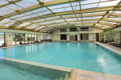 a large indoor swimming pool with a glass ceiling at Infinity view 2 Shkorpilovci in Shkorpilovtsi