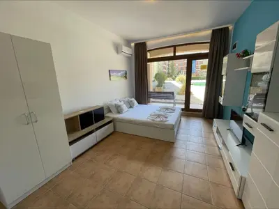 a small bedroom with a bed and a large window at Menada Kalia Apartments in Sunny Beach