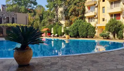 a potted plant sitting next to a swimming pool at Menada Kalia Apartments in Sunny Beach
