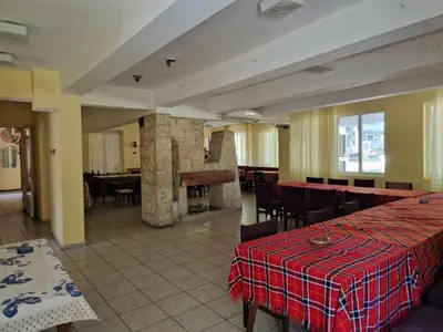 a dining room with tables and chairs and a piano at Хижа 