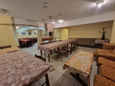 a restaurant with tables and chairs in a room at Хижа 