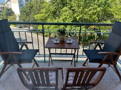 a patio with a table and chairs on a balcony at Nesebar City Apartment in Nesebar