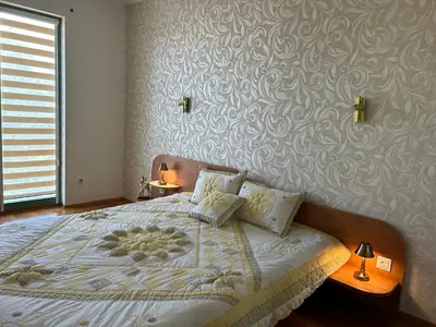 a bedroom with a bed with a patterned wall at Nesebar City Apartment in Nesebar