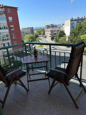 a table and chairs on a balcony with a bottle of wine at Nesebar City Apartment in Nesebar