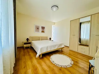 a bedroom with a white bed and a wooden floor at Vacation apartments Daneli in Sunny Beach