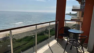 a balcony with a table and chairs and the ocean at Zigrabay lovely appartments in Primorsko