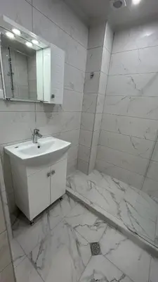 a white bathroom with a sink and a mirror at Zigrabay lovely appartments in Primorsko