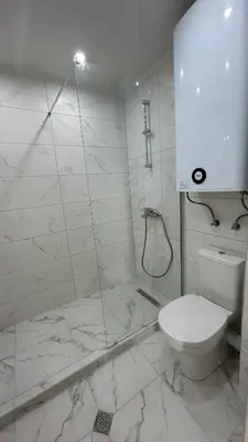 a white bathroom with a toilet and a shower at Zigrabay lovely appartments in Primorsko