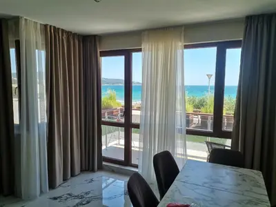 a dining room with a table and a view of the ocean at Zigrabay lovely appartments in Primorsko