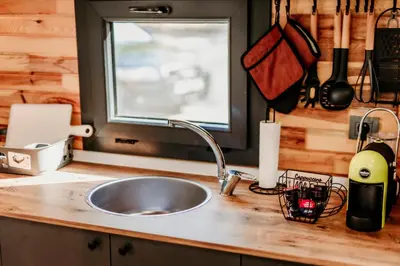 a kitchen counter with a sink and a window at Lion's Forest in Atiya