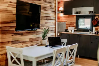 a kitchen with a table with a laptop on it at Lion's Forest in Atiya