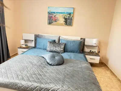 a bedroom with a bed with a blue comforter at MaYana Beach Appartament in Burgas City