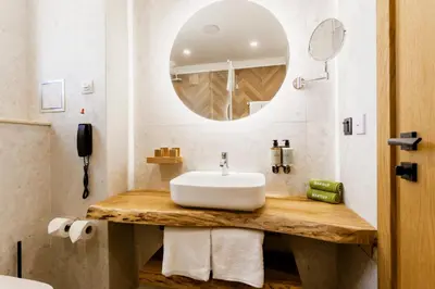 a bathroom with a sink and a mirror at Natura All Seasons Boutique Hotel in Burgas City