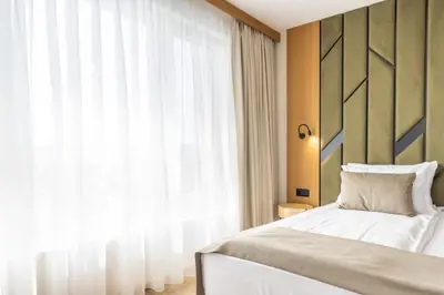 a bedroom with a bed and a large window at Natura All Seasons Boutique Hotel in Burgas City