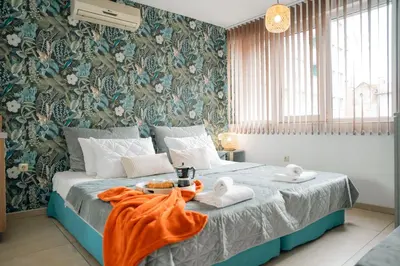 a bedroom with a bed with towels on it at Стилен и уютен апартамент в центъра Варна in Varna City