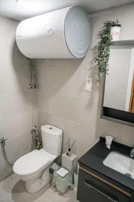 a bathroom with a toilet and a sink and a mirror at Стилен и уютен апартамент в центъра Варна in Varna City