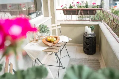 a table with a bowl of fruit on a balcony at Стилен и уютен апартамент в центъра Варна in Varna City