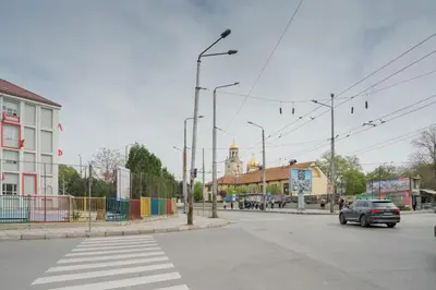 a street with a car driving down the street at Стилен и уютен апартамент в центъра Варна in Varna City