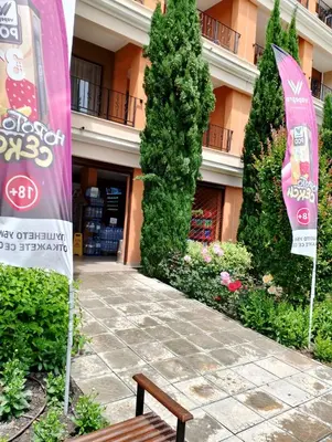 a bench in front of a building with a sign at Private Apartment in PREMIER FORT Beach Aparthotel in Sveti Vlas
