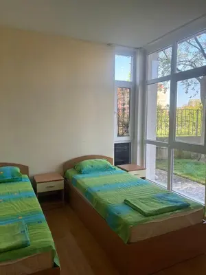 two beds in a room with two windows at Апартамент Бриджит Слънчев бряг in Sunny Beach