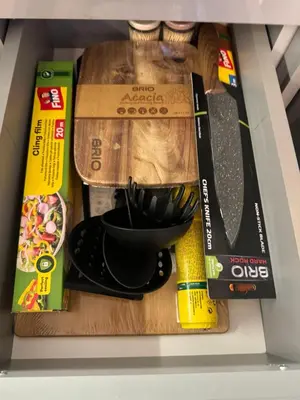 a shelf with a cutting board and other kitchen utensils at Апартамент Панорама Славейков in Burgas City