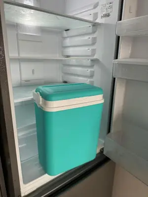 an empty refrigerator with a blue trash can in it at Апартамент Панорама Славейков in Burgas City