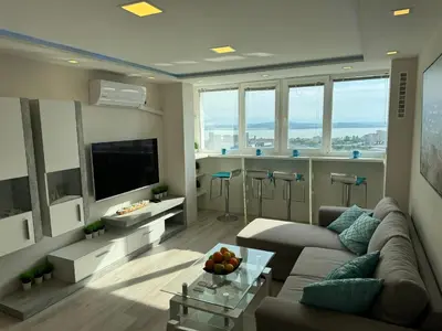a living room with a couch and a table at Апартамент Панорама Славейков in Burgas City