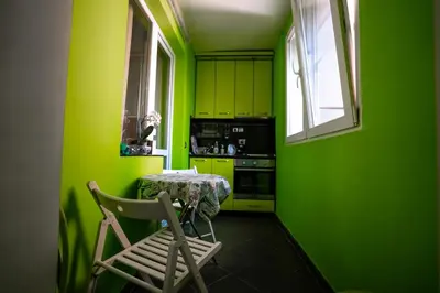 a green kitchen with a table and a chair at Seaside Apartament in Burgas City