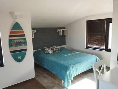 a bedroom with a surfboard on the wall next to a bed at Горе на вилата in Shkorpilovtsi