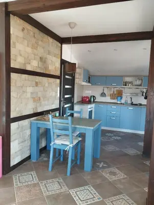 a blue kitchen with a blue table and chairs at Горе на вилата in Shkorpilovtsi