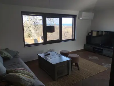 a living room with a couch and a tv at Горе на вилата in Shkorpilovtsi