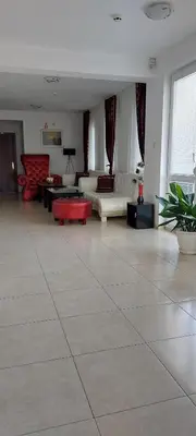 a large living room with couches and tables at Семеен Хотел ''Кораб Ренеса'' in Ravda