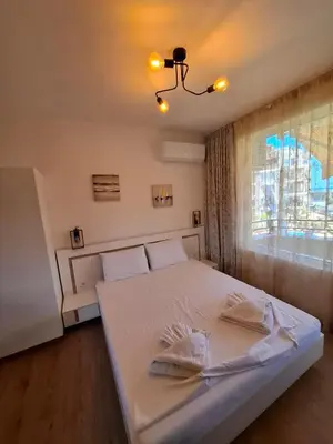 a white bed in a room with a window at LaRenta Стилни апартаменти с 2 спални и гледка море в Свети Влас in Sveti Vlas