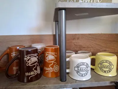 a row of coffee mugs sitting on a shelf at LaRenta Стилни апартаменти с 2 спални и гледка море в Свети Влас in Sveti Vlas