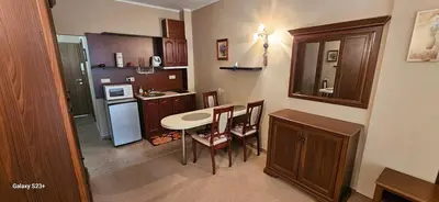 a small kitchen with a table and chairs in it at Частно студио в комплекс Поморие Ризорт in Pomorie