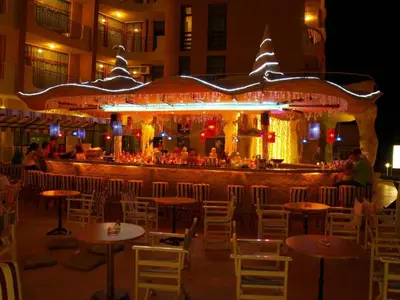a restaurant with tables and chairs in front of a bar at Grenada - Apartments by the beach in Sunny Beach