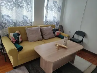 a living room with a yellow couch and a coffee table at rozi in Burgas City