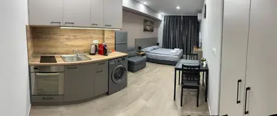 a kitchen with a sink and a room with a bed at Студио Комфорт Бургас Център in Burgas City