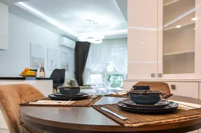 a kitchen with a wooden table with plates on it at Boutique 1 bedroom apartment with Private Parking and Port View in Varna City