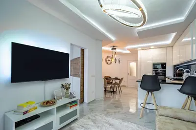 a living room with a flat screen tv on a wall at Boutique 1 bedroom apartment with Private Parking and Port View in Varna City
