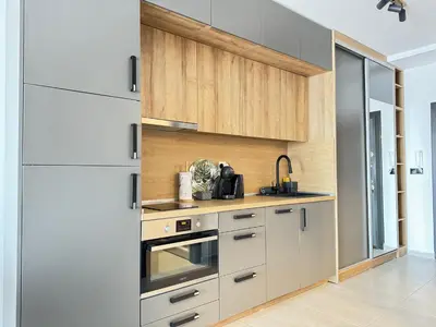 a kitchen with white cabinets and a sink at Sea la Vie in Sozopol