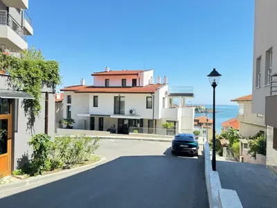 a car driving down a street in front of a house at Sea la Vie in Sozopol
