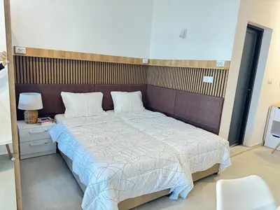 a bedroom with a large bed with a wooden headboard at Wave & Sea in Sozopol
