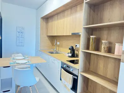 a kitchen with wooden cabinets and a sink and a chair at Wave & Sea in Sozopol
