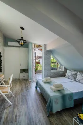 a bedroom with a large bed and a chair at Bella in Nesebar