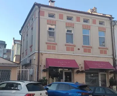 a building with cars parked in front of it at The Central House 1 in Burgas City