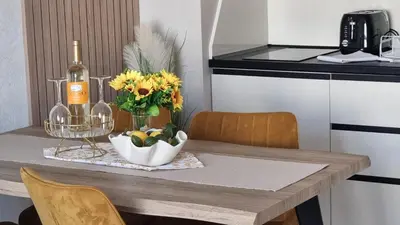 a table with a vase of flowers and a bottle of wine at Sorrento Sole Mare V&D Luxury Style Apartment in Sveti Vlas