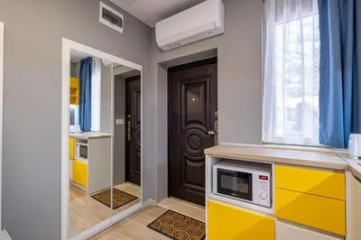 a kitchen with yellow and white cabinets and a door at Apartment Linda Cosy Getaway in Varna City