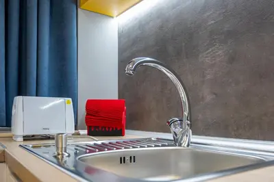 a kitchen sink with a faucet and a red towel at Apartment Linda Cosy Getaway in Varna City